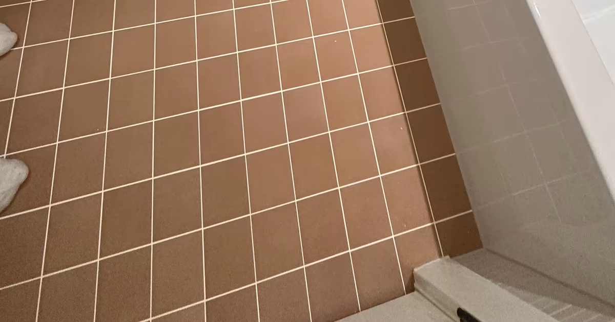 Finished terracotta-look floor tile around the toilet and alcove tub in an Arvada, CO bathroom remodel