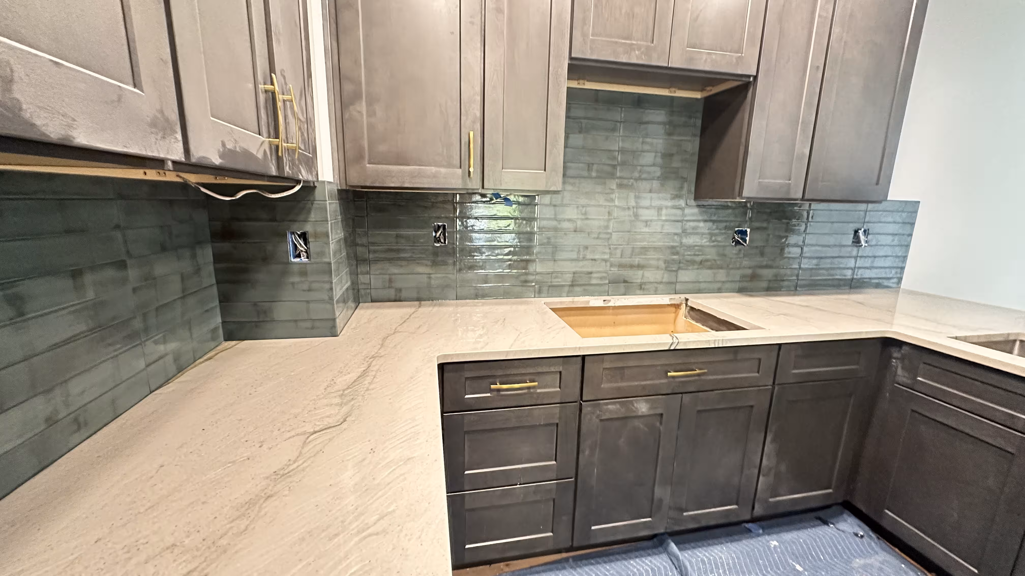 Installing dark green porcelain subway tile backsplash in Aurora kitchen