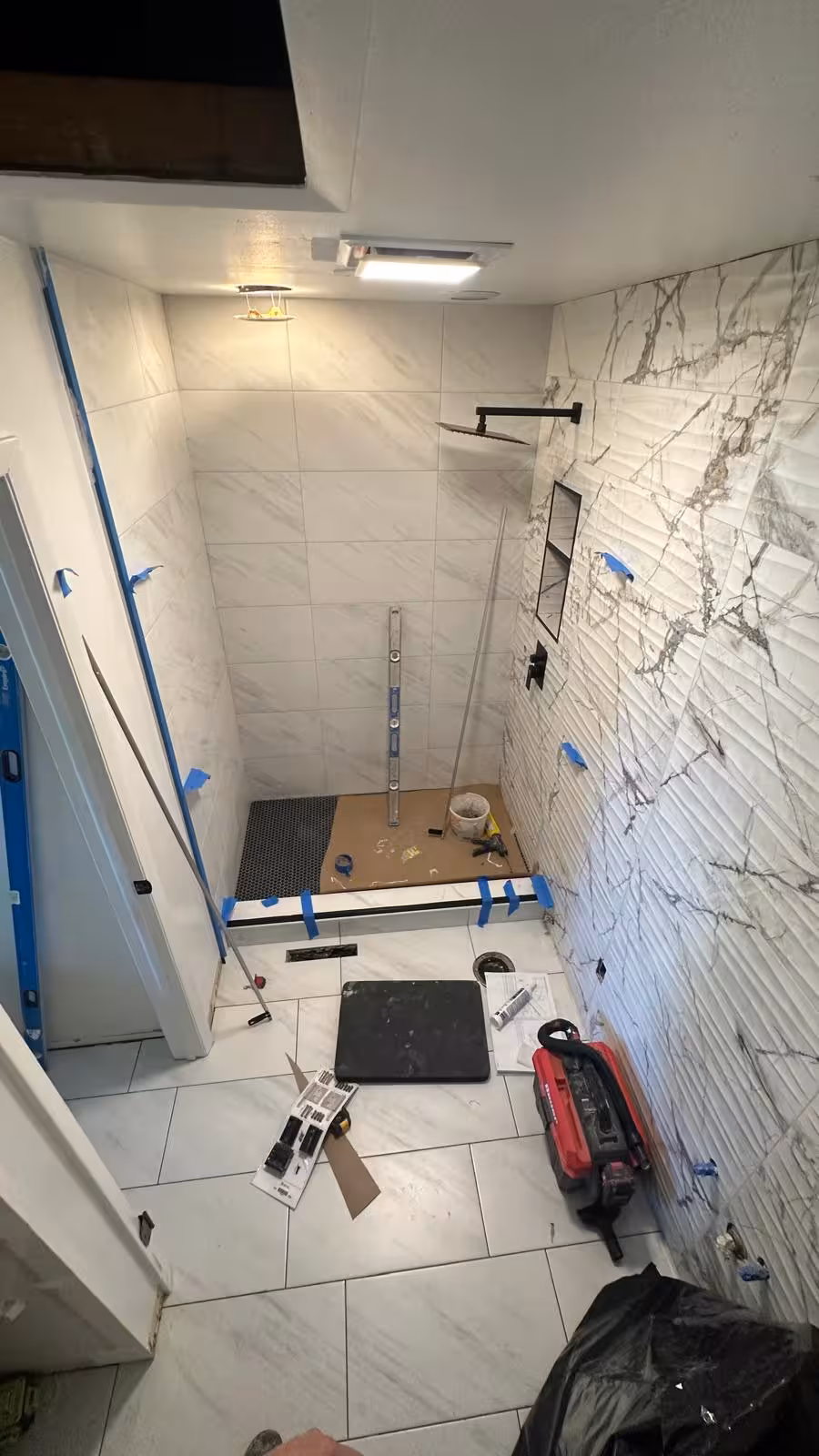 Wave-pattern accent wall tile and shower niche installation in Aurora shower remodel