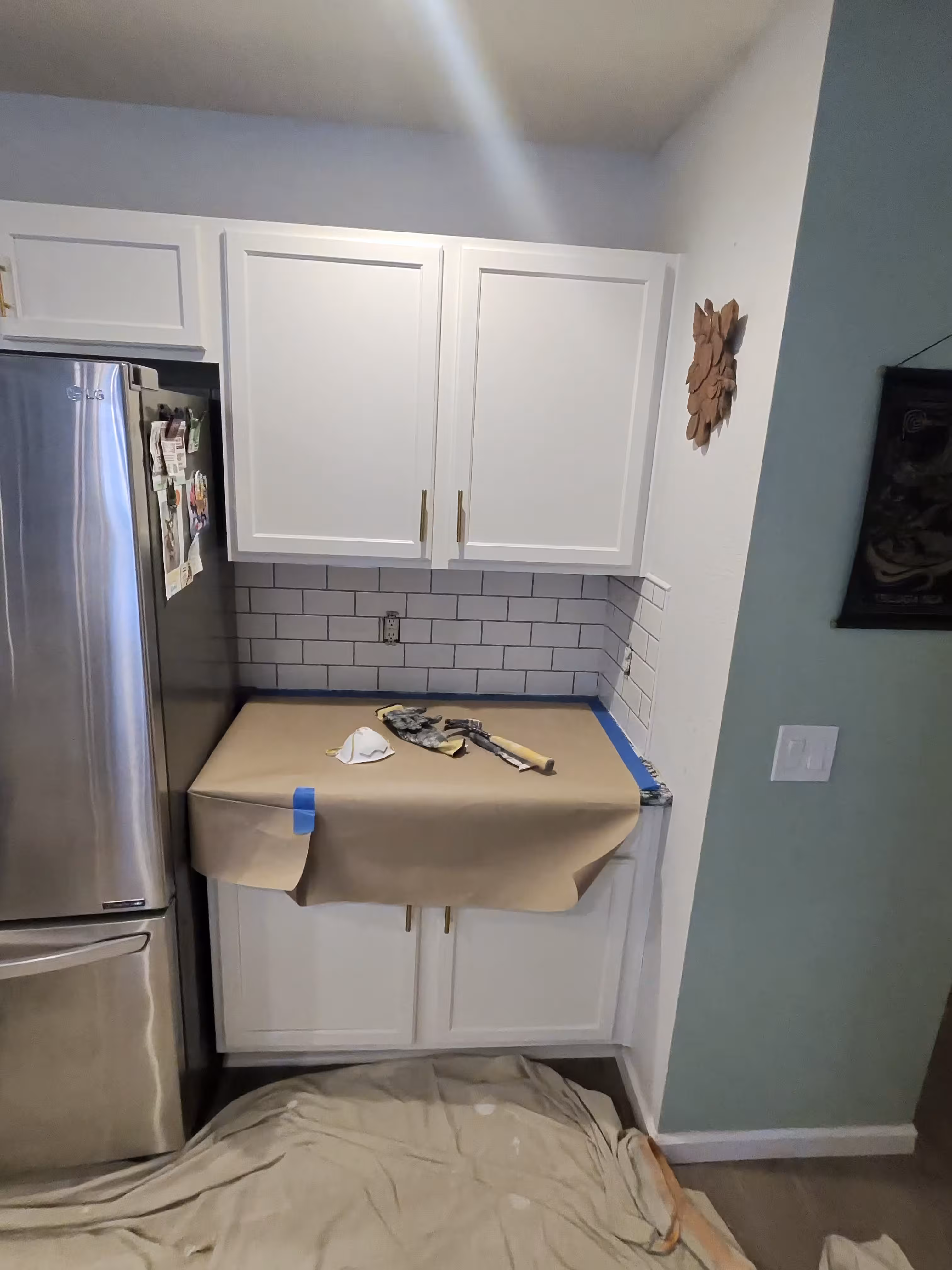 Existing white subway tile in a kitchen corner nook before tear-out in an Aurora, CO home