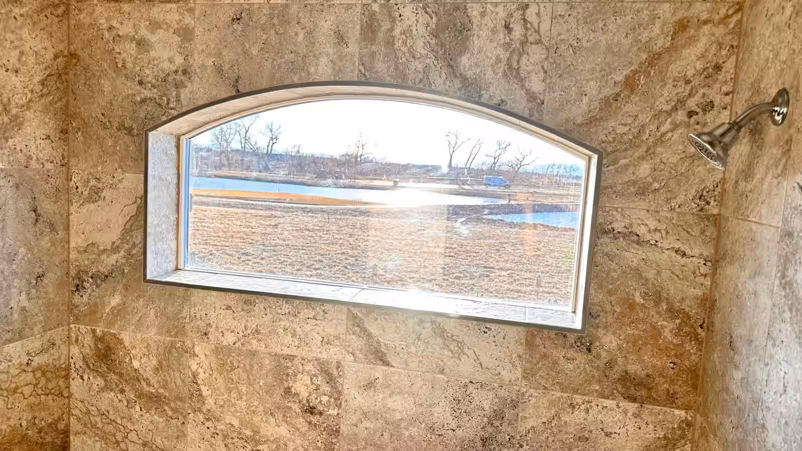 Arched window integrated into shower wall tile design completed