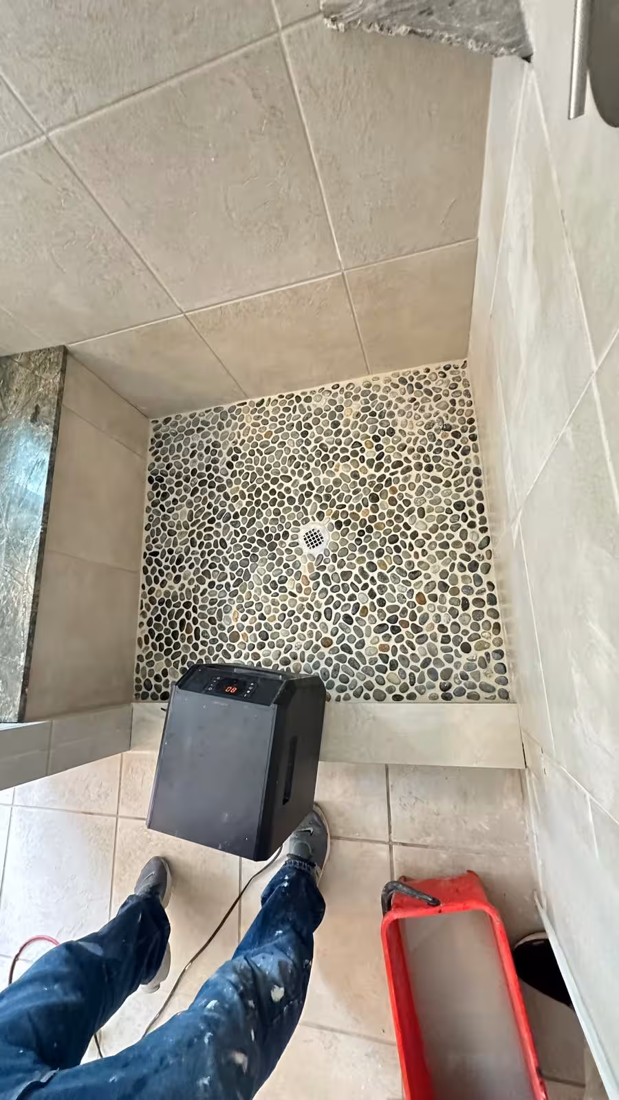 Completed pebble mosaic shower floor after shower pan repair in the DTC area