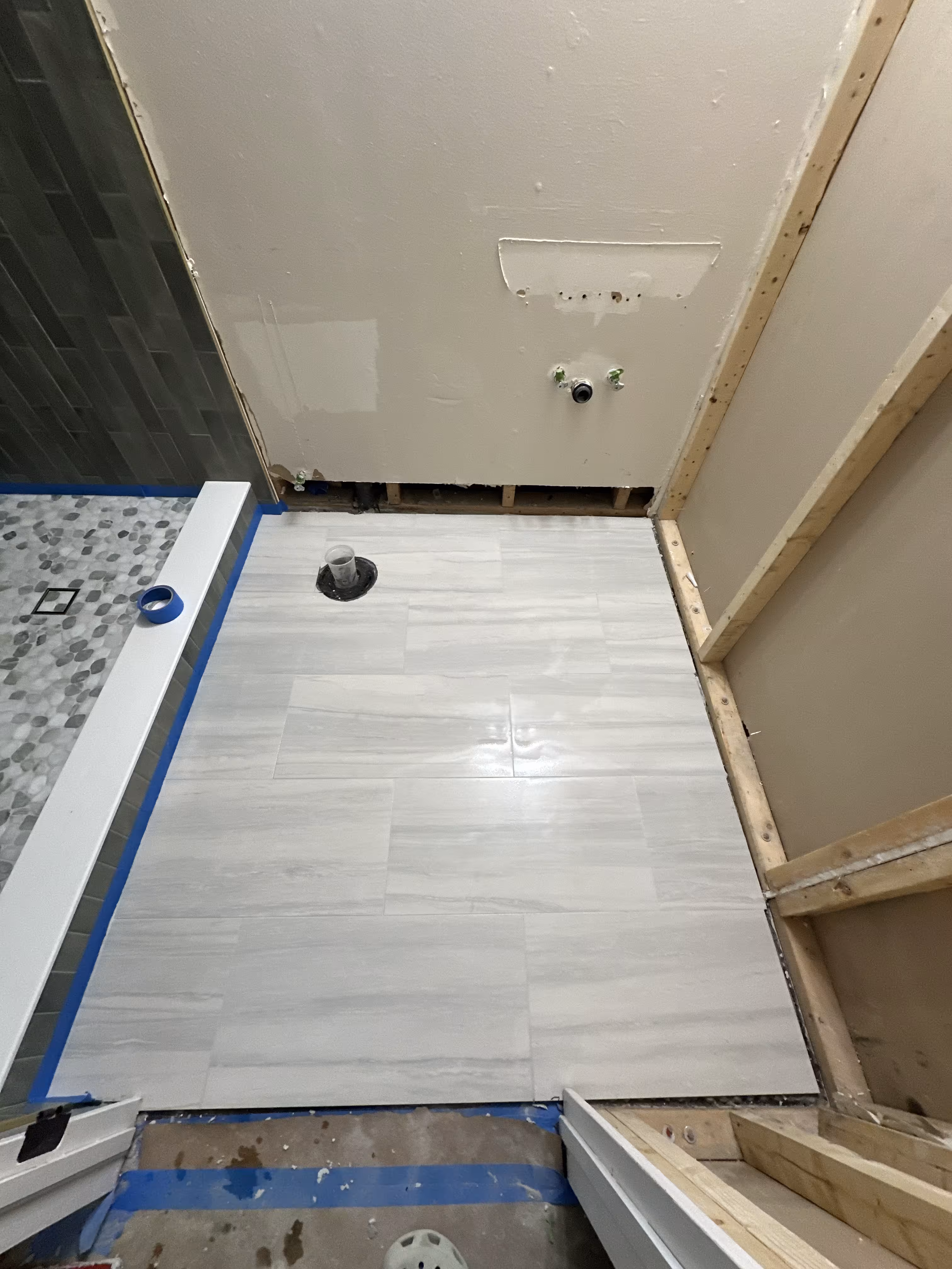 New bathroom floor tile installed next to the tiled shower in Commerce City