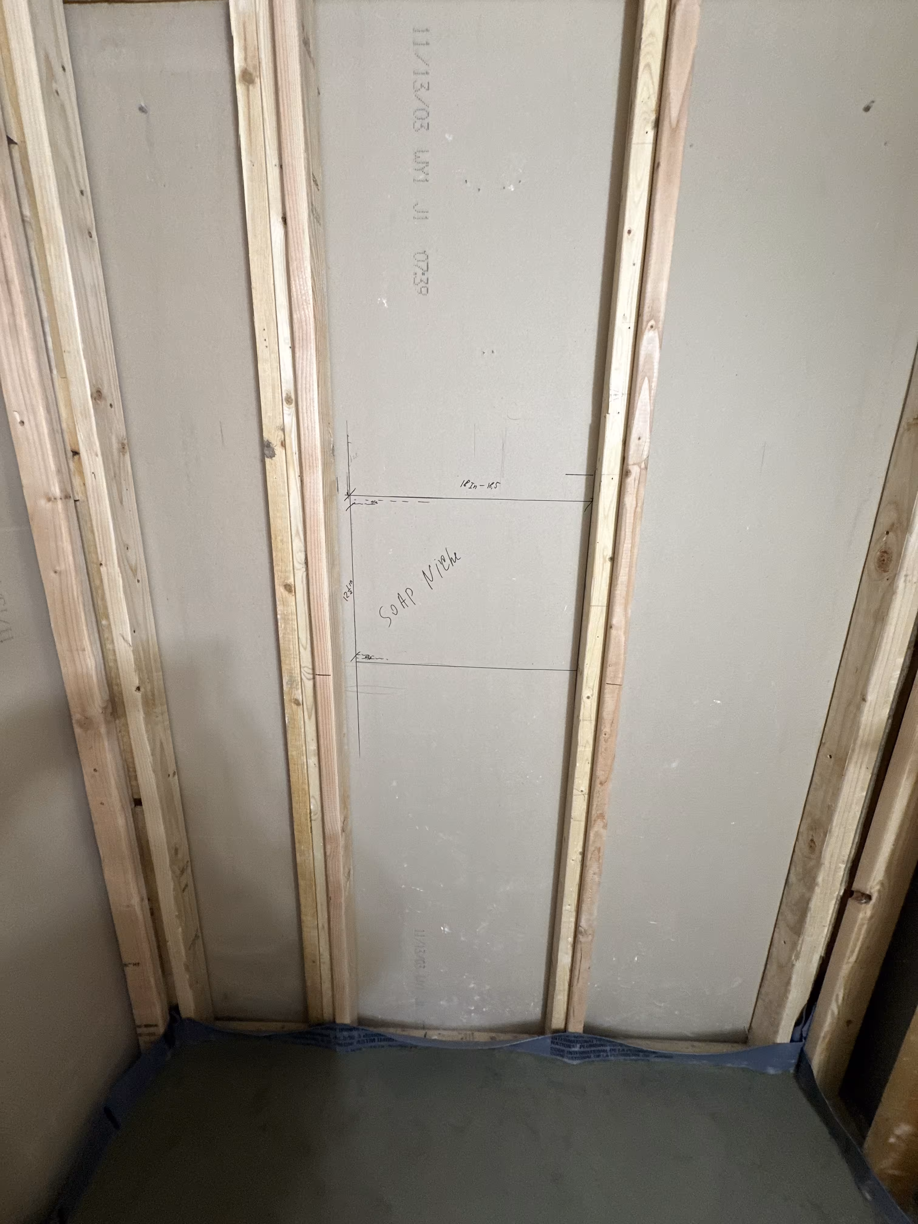 Cement backer board with soap niche dimensions penciled in before tiling