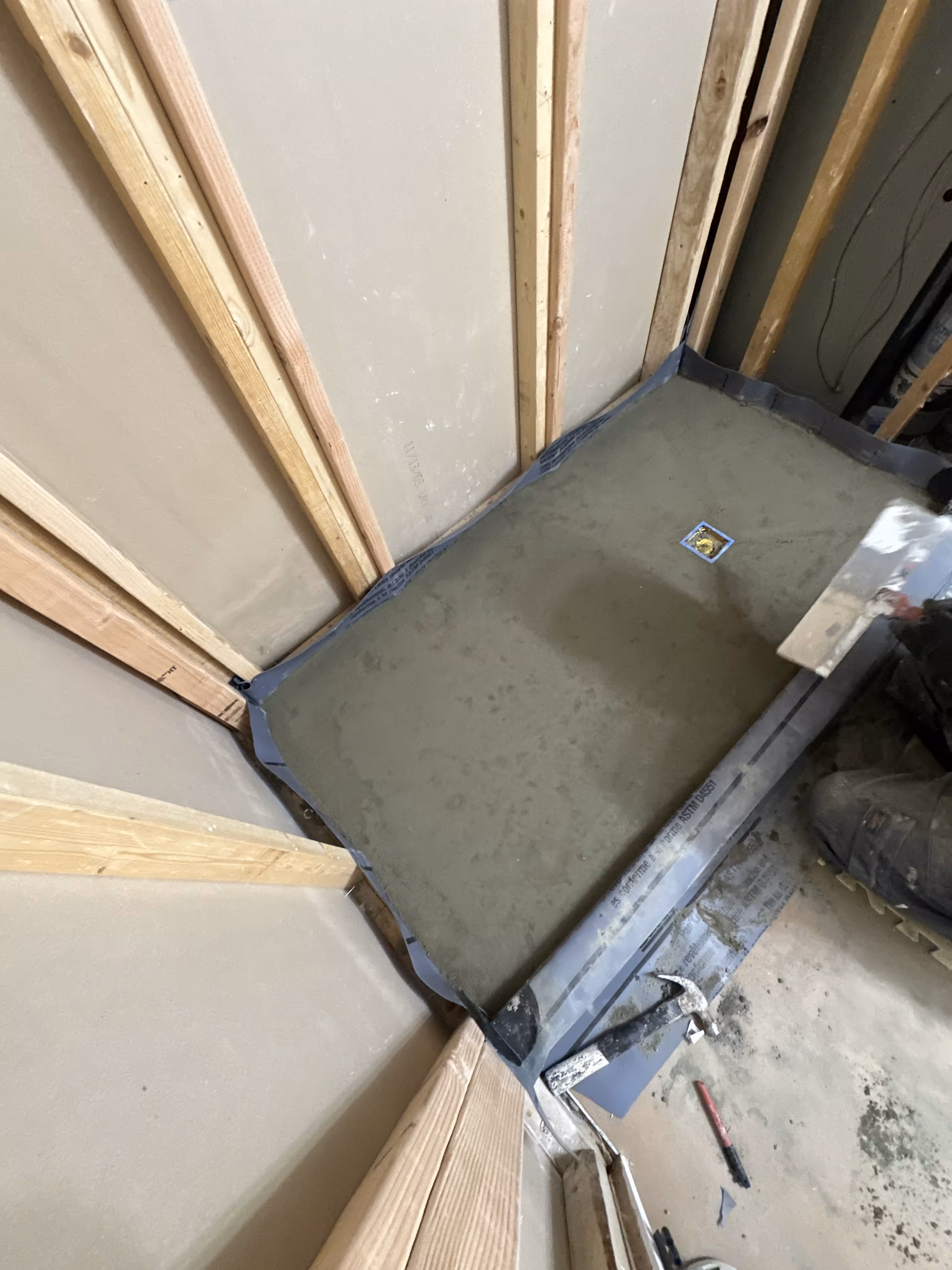 Freshly floated deck-mud shower pan over a waterproof liner during the Commerce City shower remodel