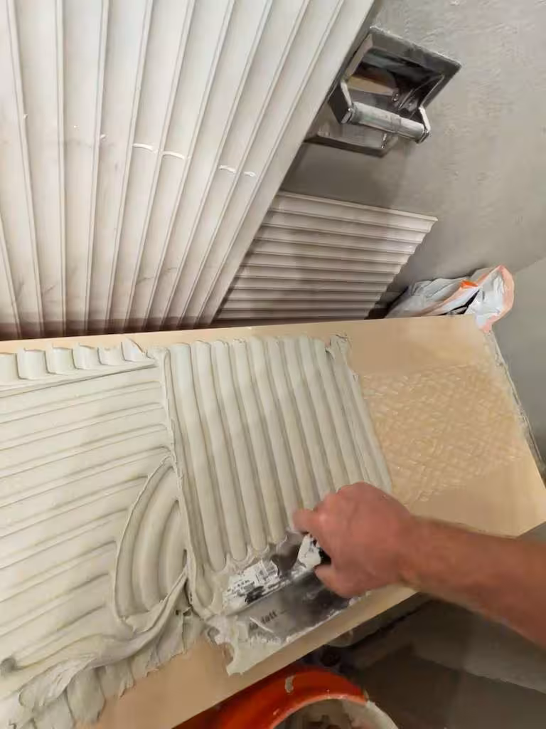 Applying thinset mortar to textured vertical tile during installation