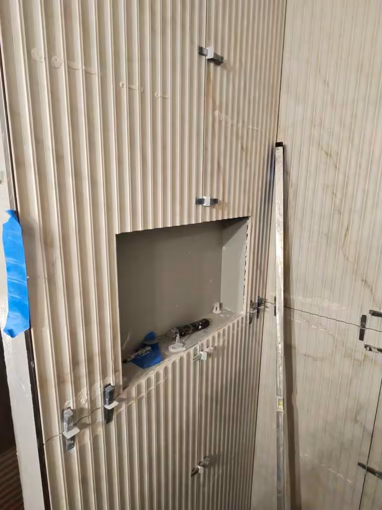 In-progress shower niche installation showing textured tile alignment