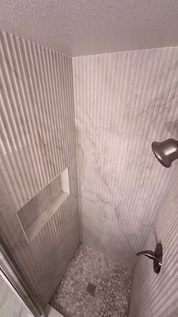 Finished shower niche installation with vertical textured tile surround