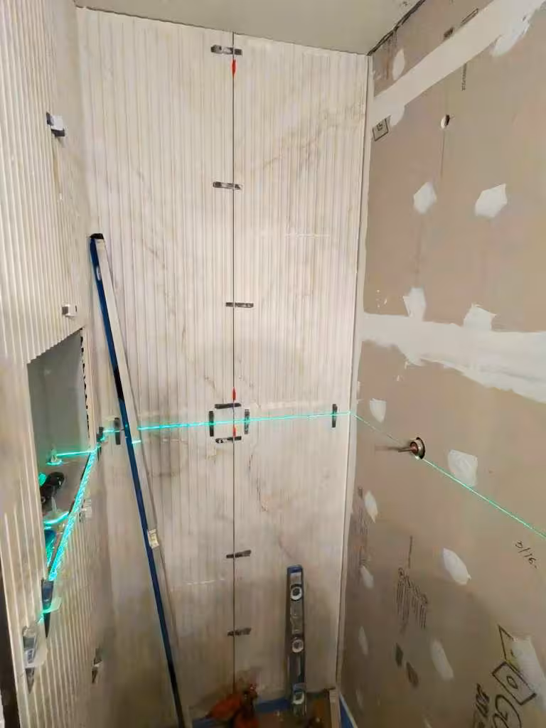 Using laser level for precise vertical tile installation alignment