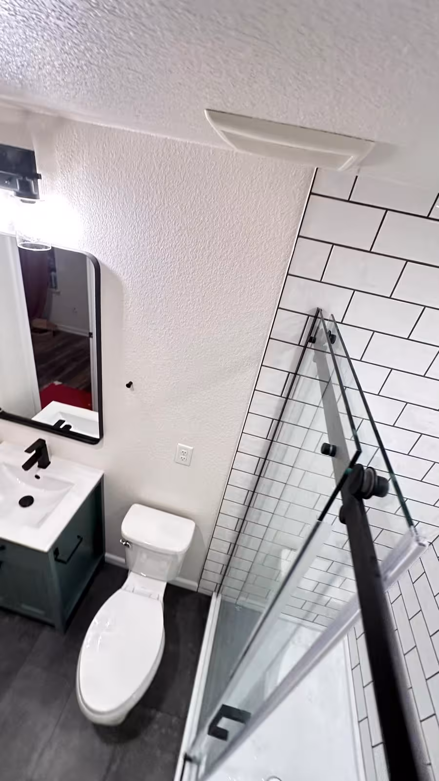 Small bathroom featuring sage green vanity and glass shower enclosure