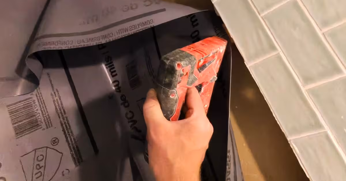 PVC shower pan liner being installed behind the wall tile of a Denver shower, the waterproofing layer that sits under tile and grout