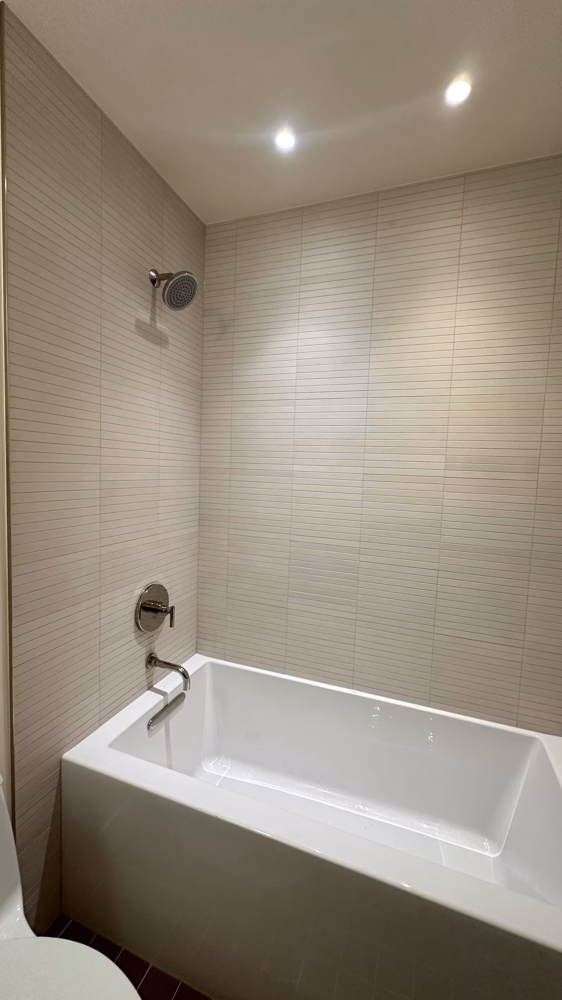 Finished alcove tub with white kit-kat tile surround and chrome fixtures in an Arvada, CO bathroom