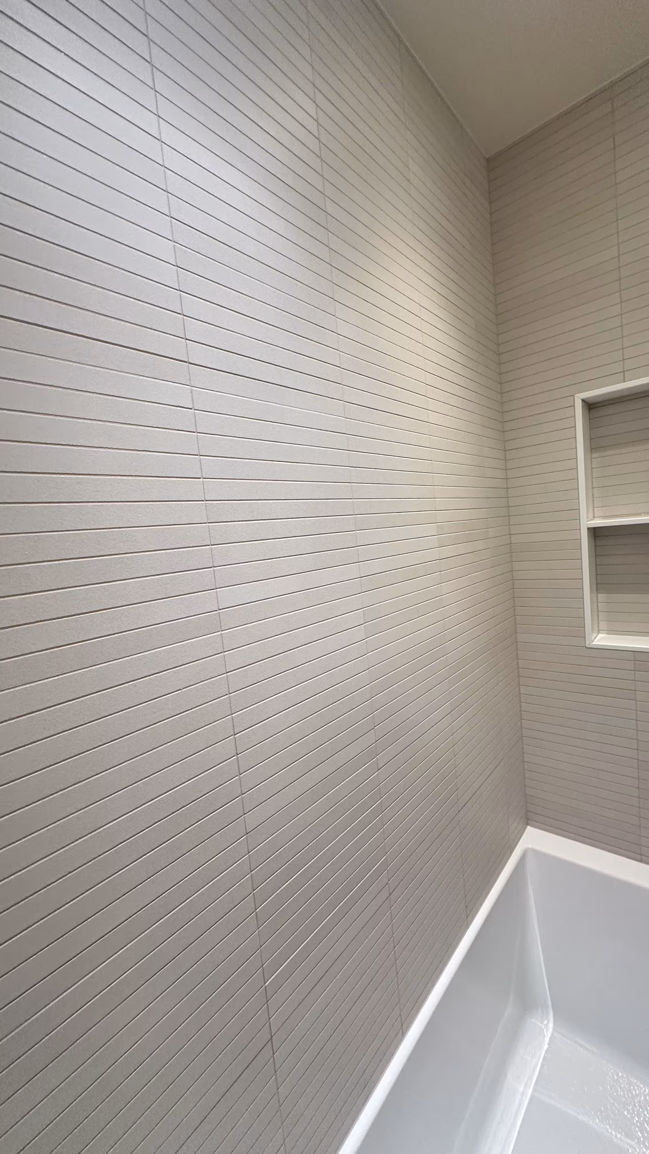 Close angle on the white kit-kat tile texture along the tub surround wall in Arvada, CO