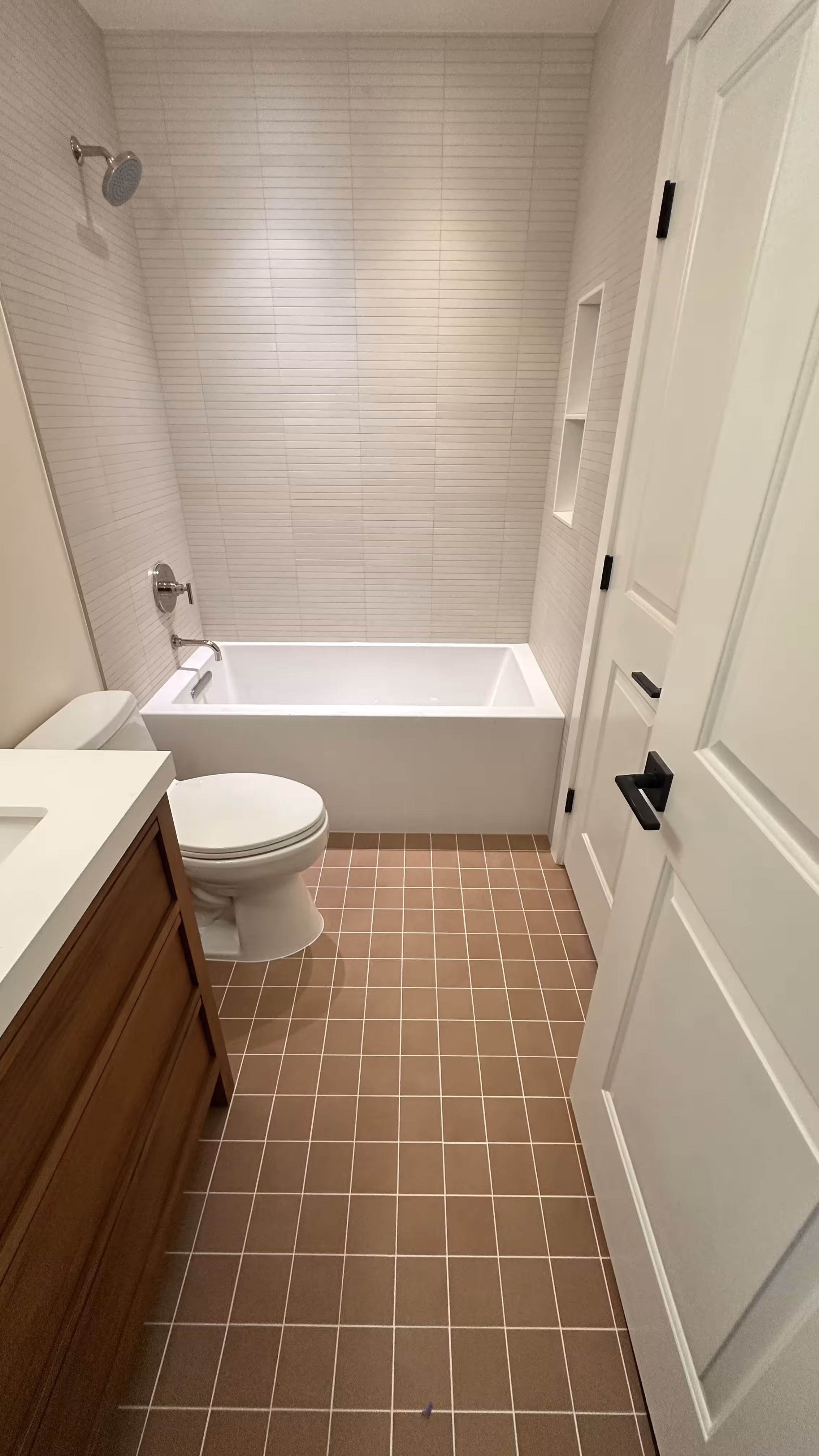 Open door view of the tub, toilet, and vanity in a finished Arvada bathroom remodel