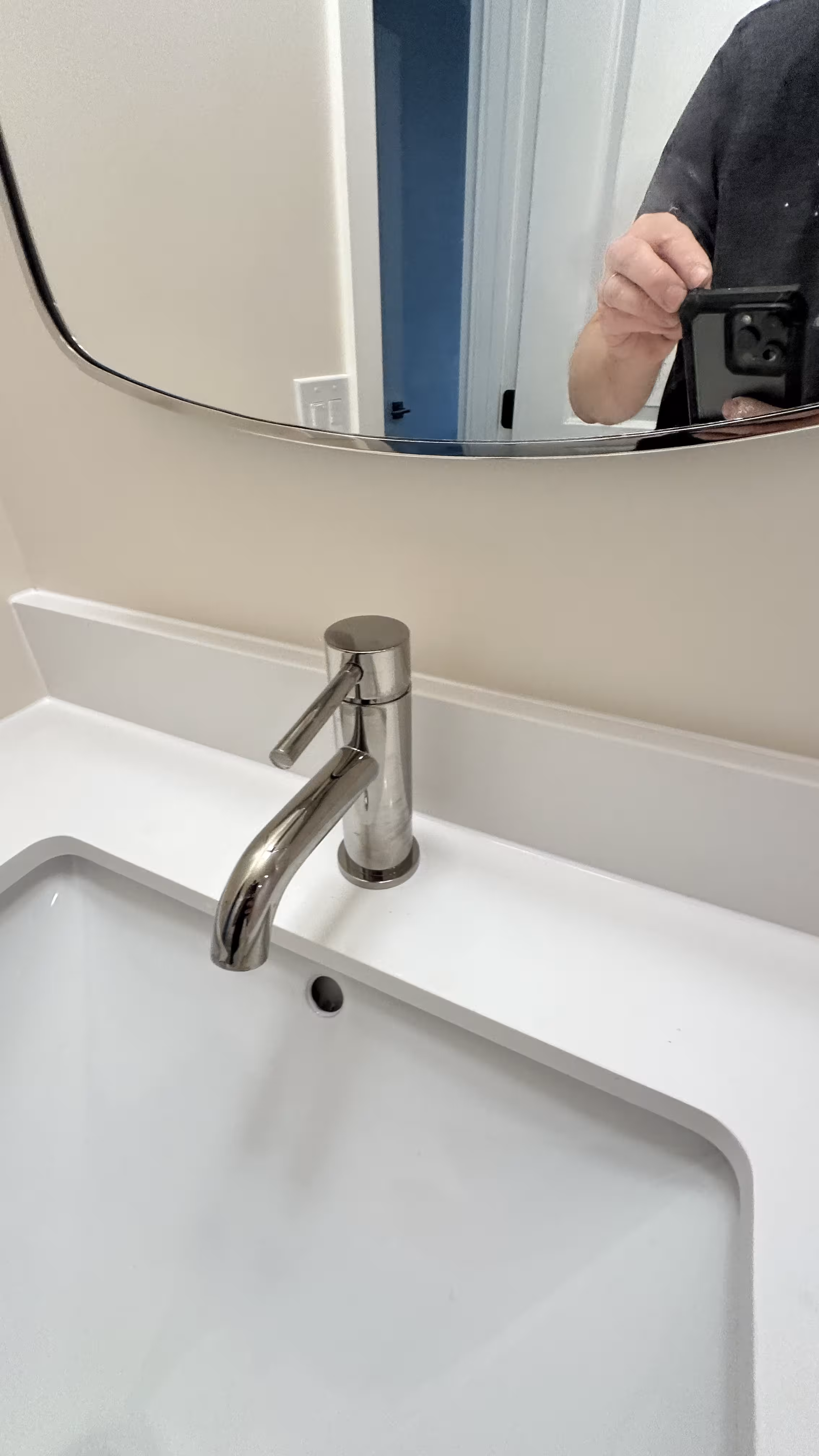 New vanity sink and chrome faucet below the mirror in a finished Arvada bathroom remodel
