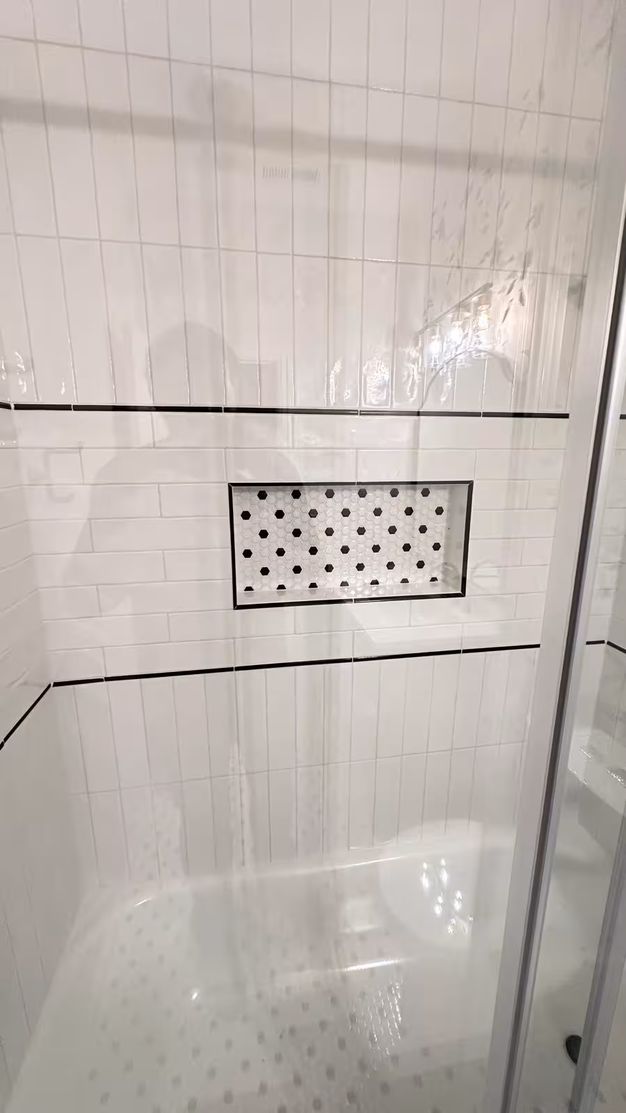 Glass tub door and tiled niche detail in designer bathroom in Aurora CO