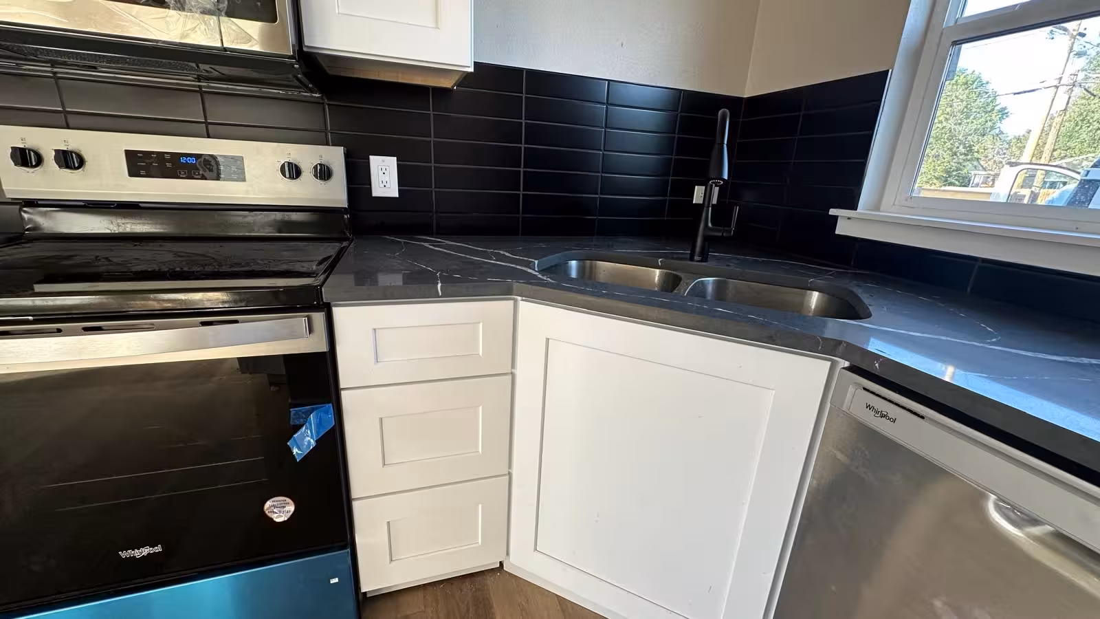 Black subway tile kitchen backsplash installation in Denver