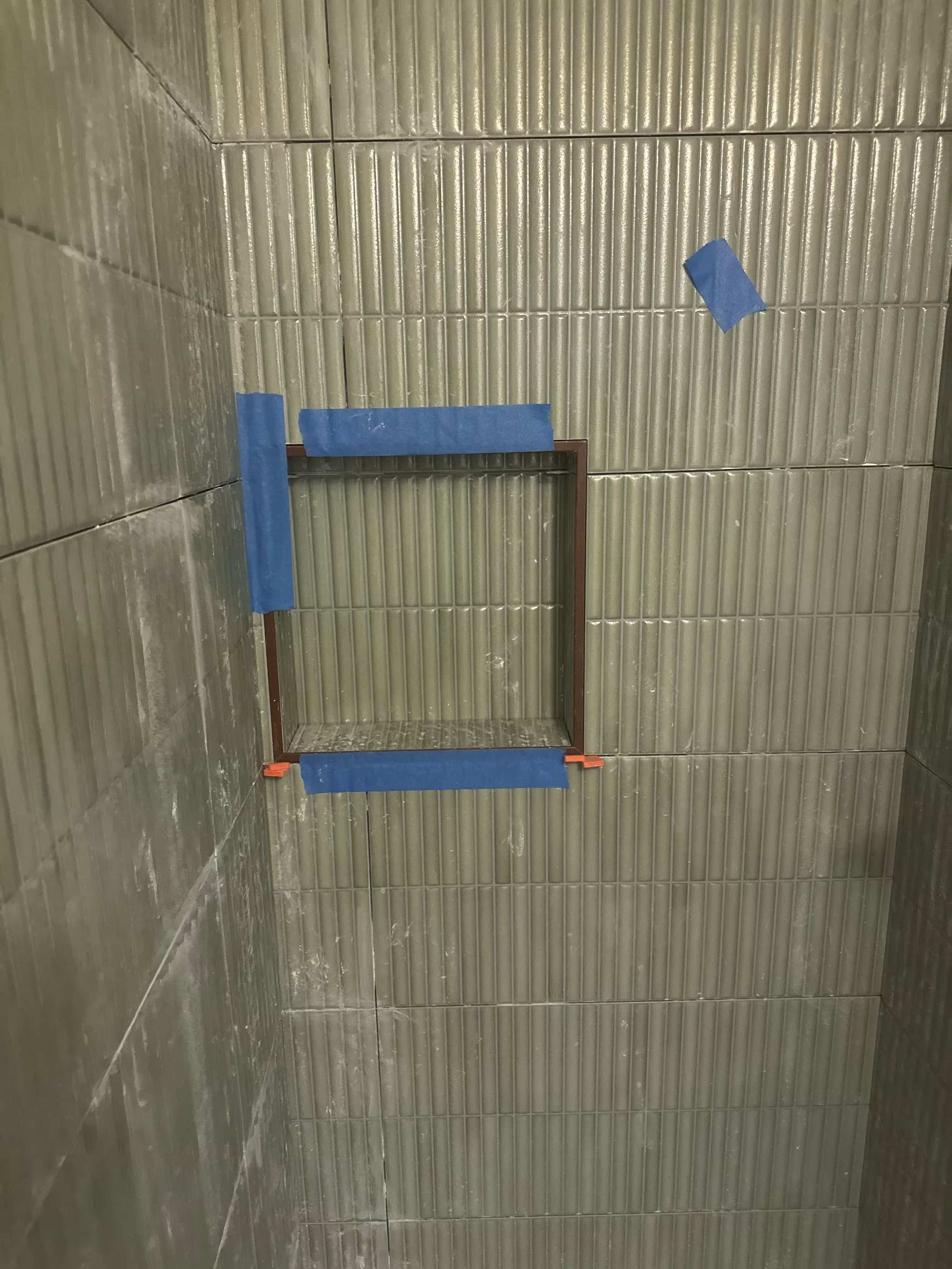 Recessed shower niche taped and trimmed mid-installation in a green fluted tile shower in Arvada, CO