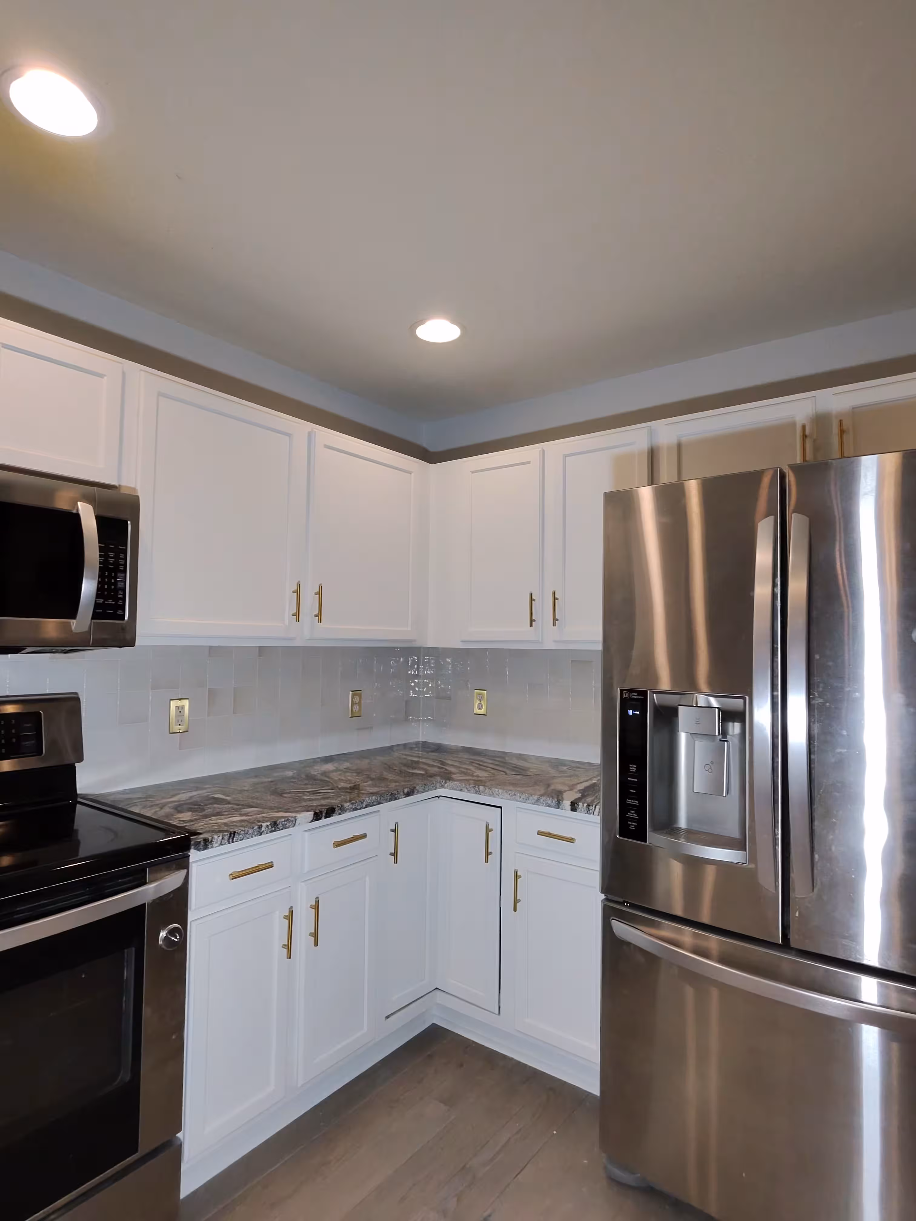 Finished glossy white square tile backsplash behind the range in an Aurora kitchen