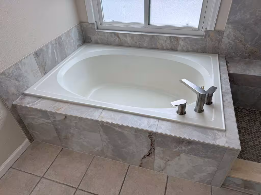 Finished master bathroom combo view of the soaking tub and walk-in shower with matching marble-look tile, Highlands Ranch remodel