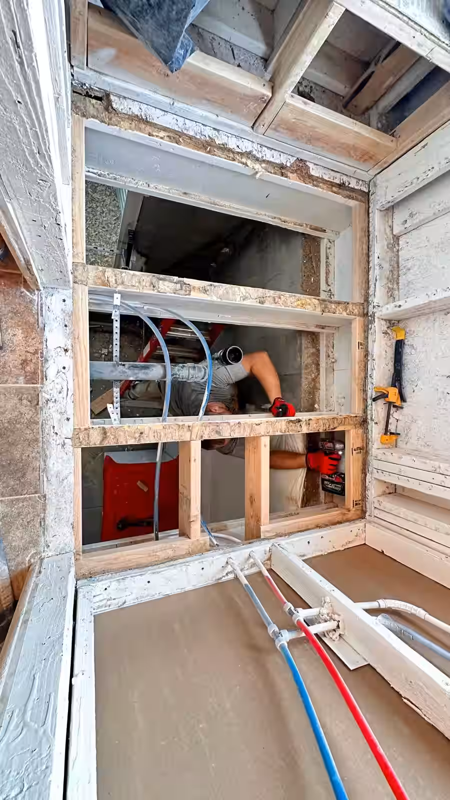 Exposed floor framing showing structural repair during shower remodel