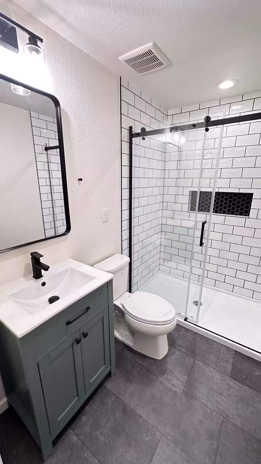 Complete bathroom remodel with sage green vanity and subway tile shower