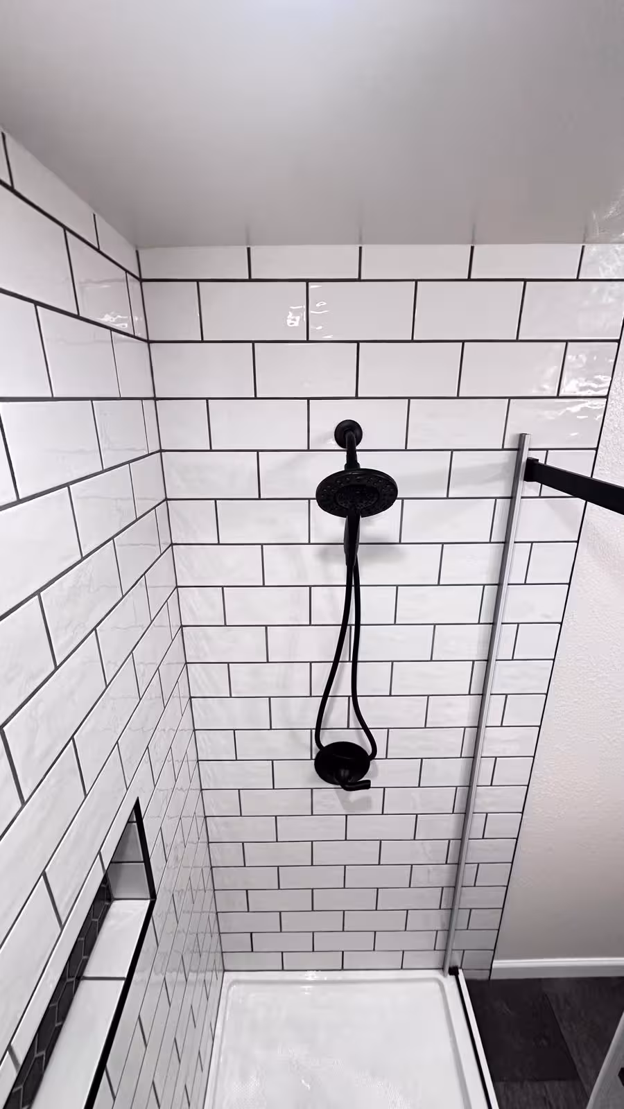 White subway tile shower with matte black rainfall showerhead and fixtures