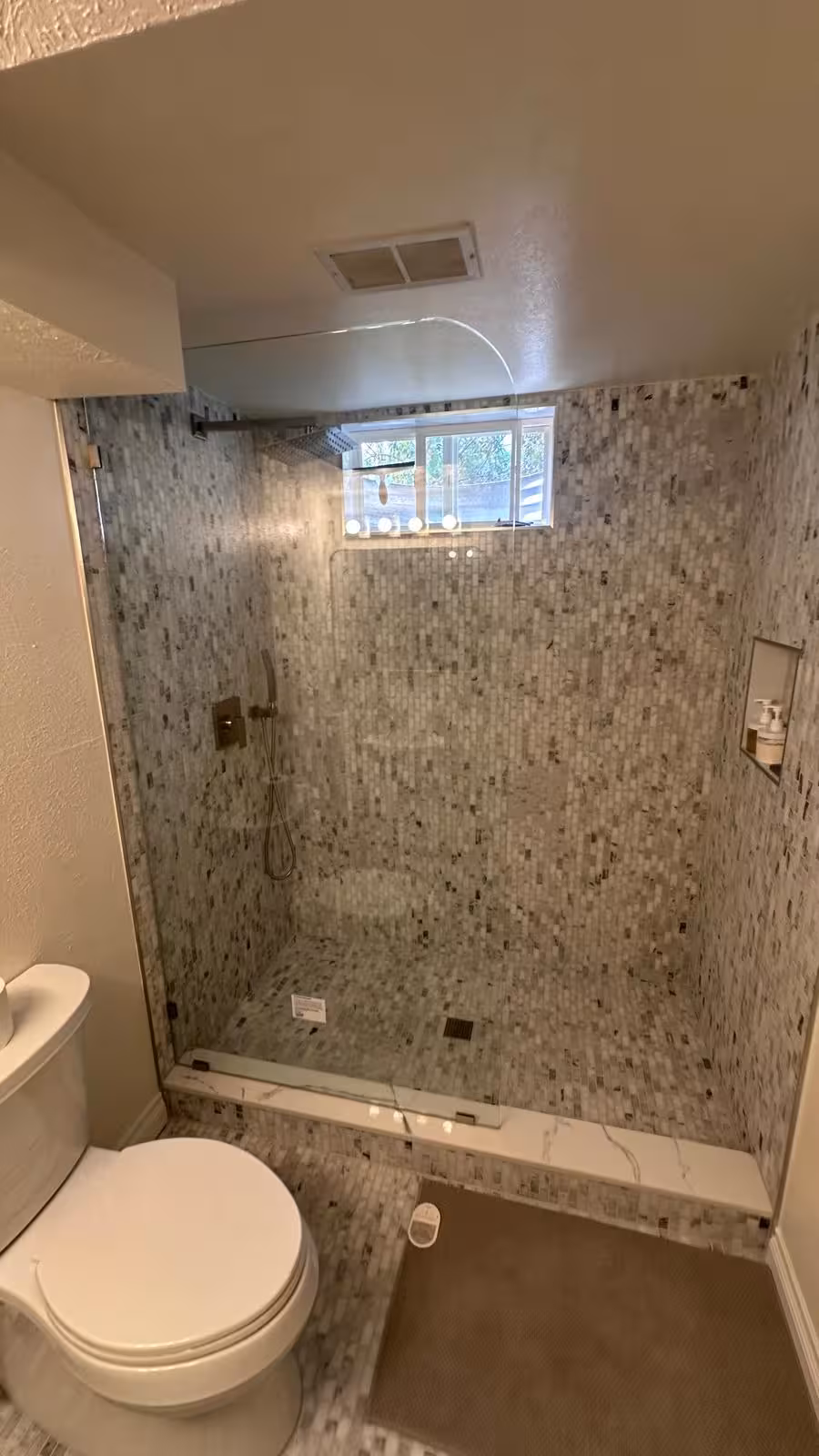Luxury basement shower with marble mosaic tile and frameless glass door Littleton