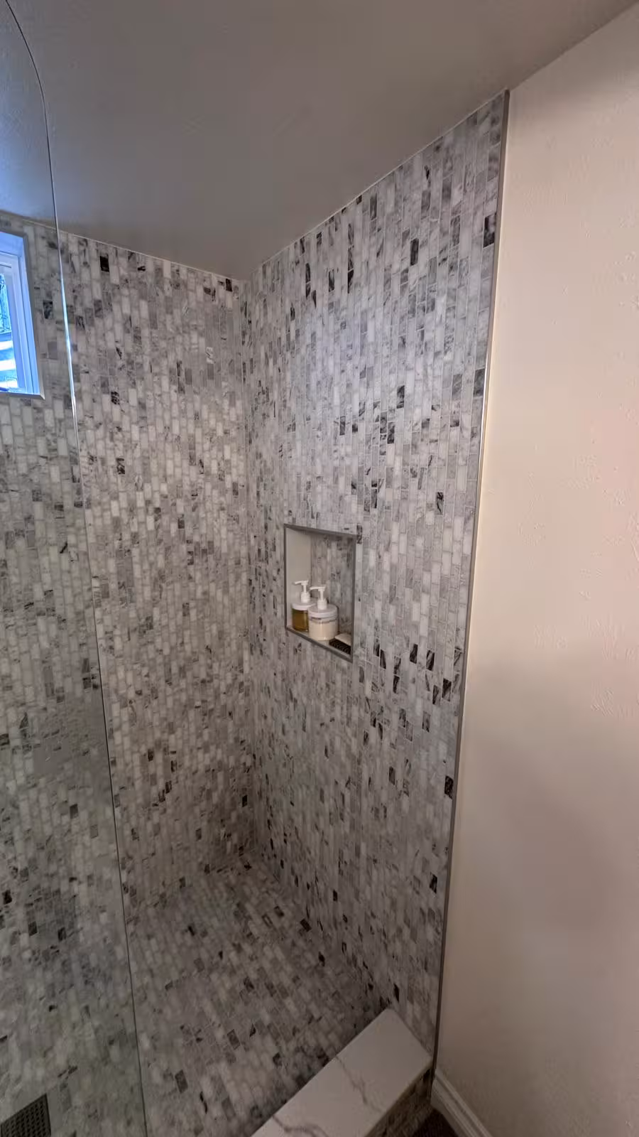 Custom shower niche detail with marble mosaic tile Littleton basement renovation