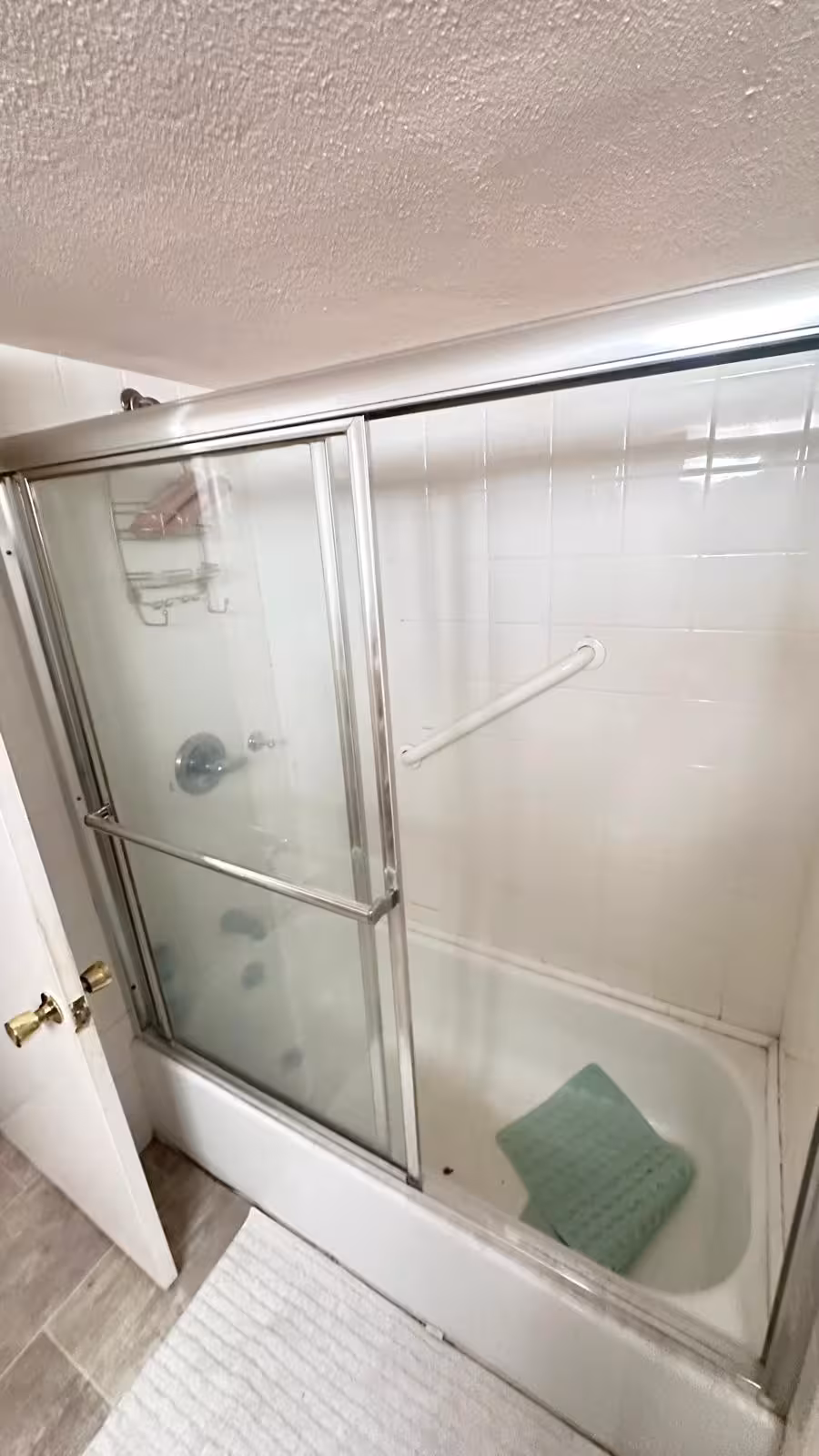 Original basement bathtub with glass doors before conversion to walk-in shower Aurora CO