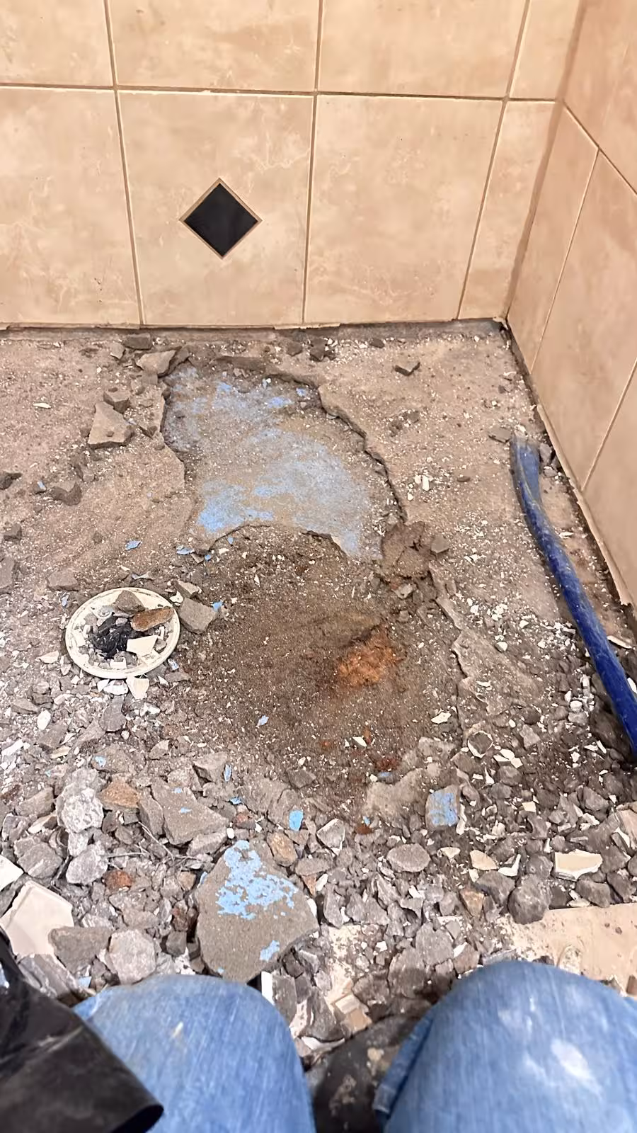 Shower pan demolition in progress with broken tile and debris removal Elizabeth Colorado repair