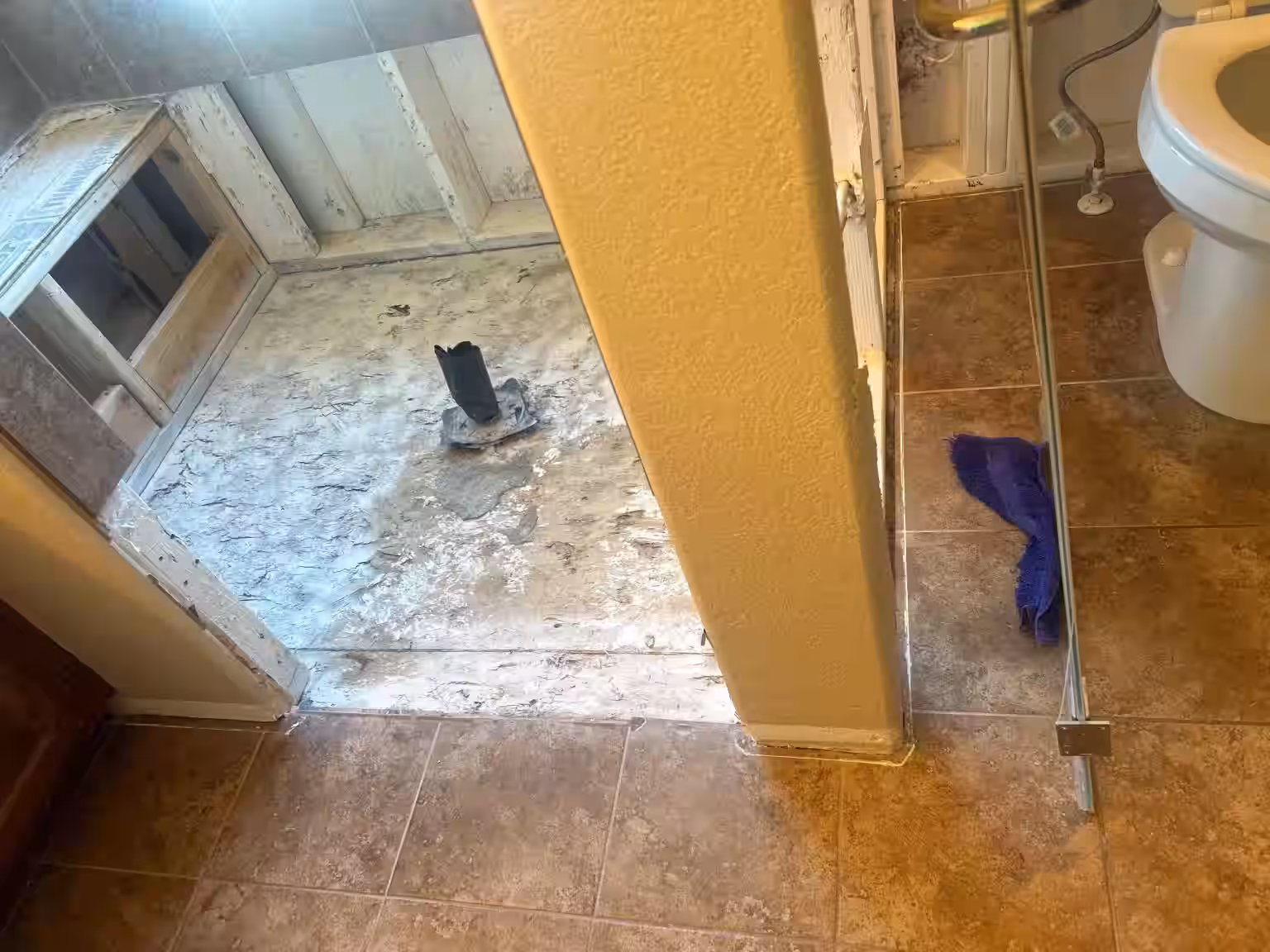 Rotted shower pan and subfloor damage from long-term water penetration