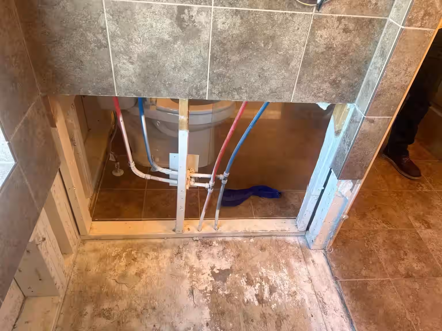 Shower wall framing and plumbing pipes exposed during water damage remediation