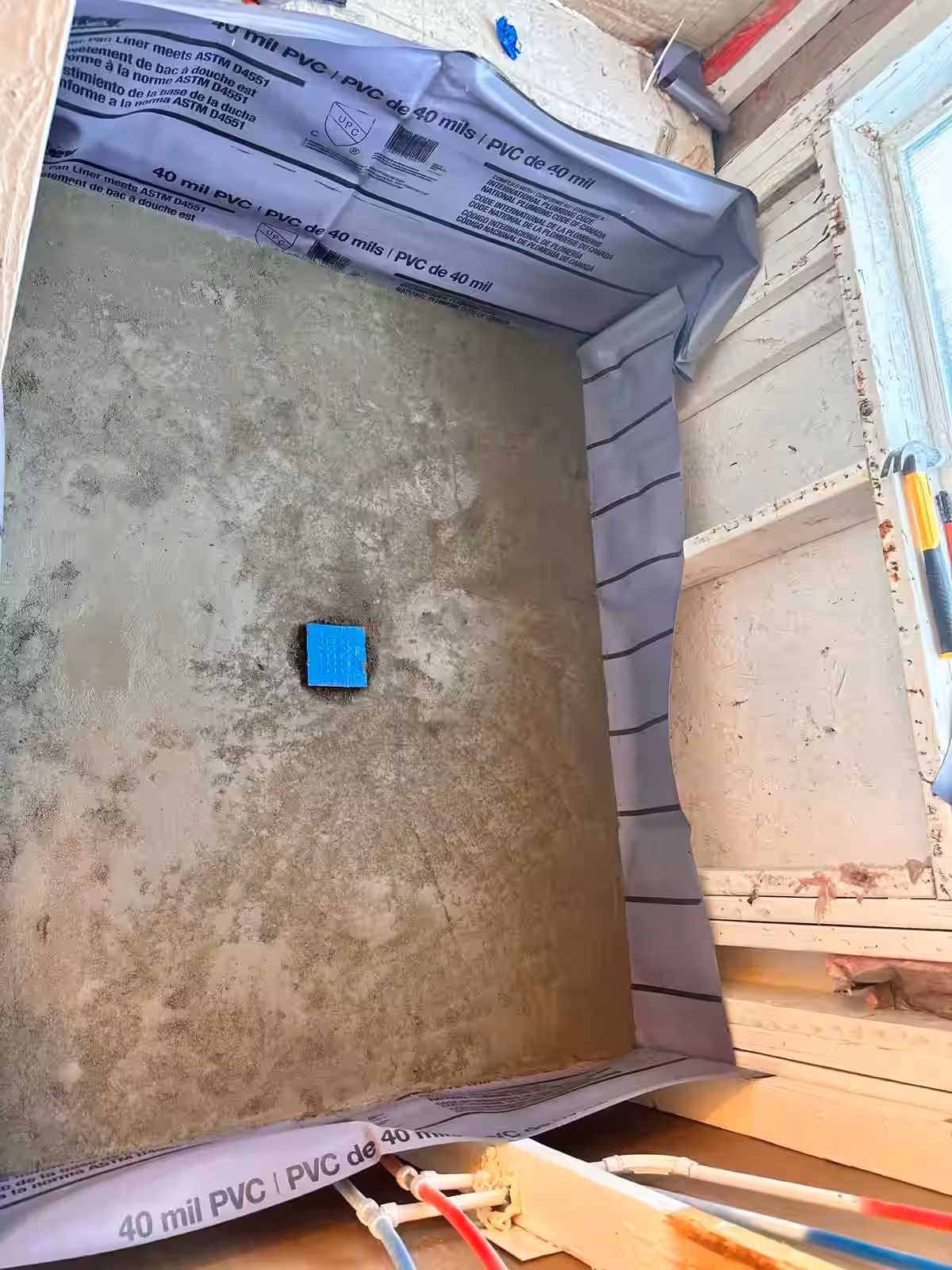 Installing 40-mil PVC shower pan liner over pre-slope mortar bed