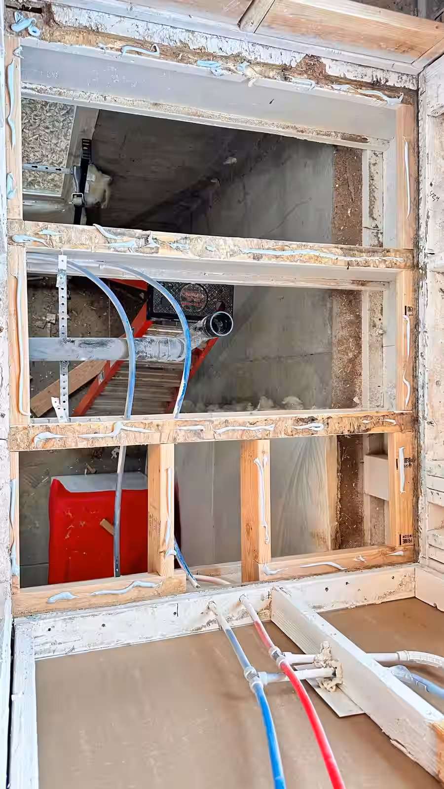Detailed view of shower plumbing connections and wall framing renovation