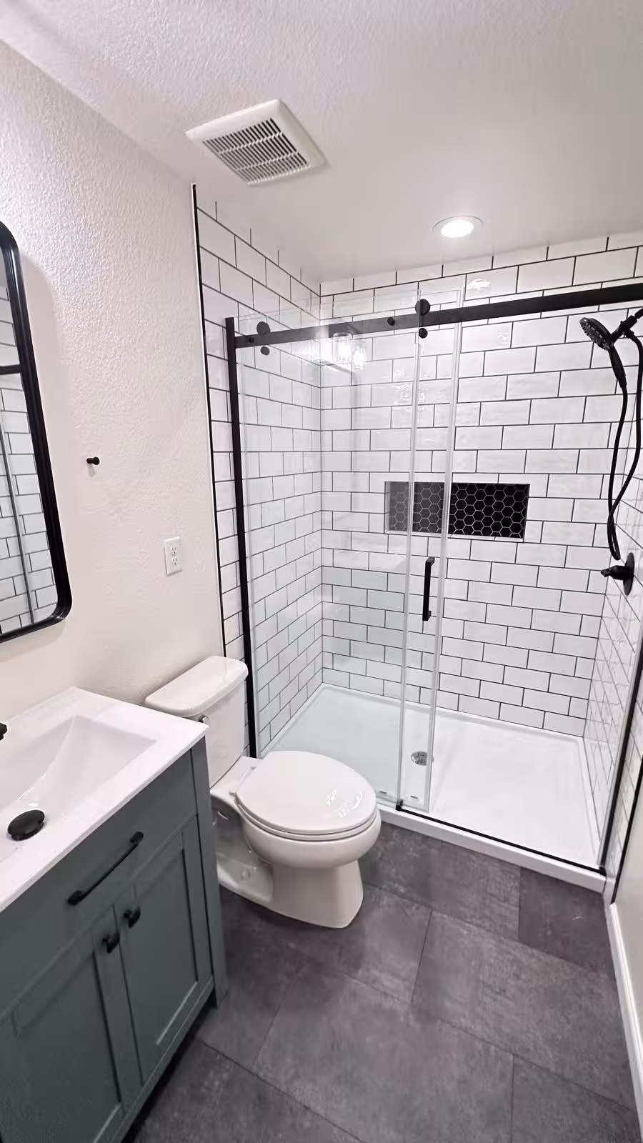 Bathroom renovation with green vanity and subway tile shower
