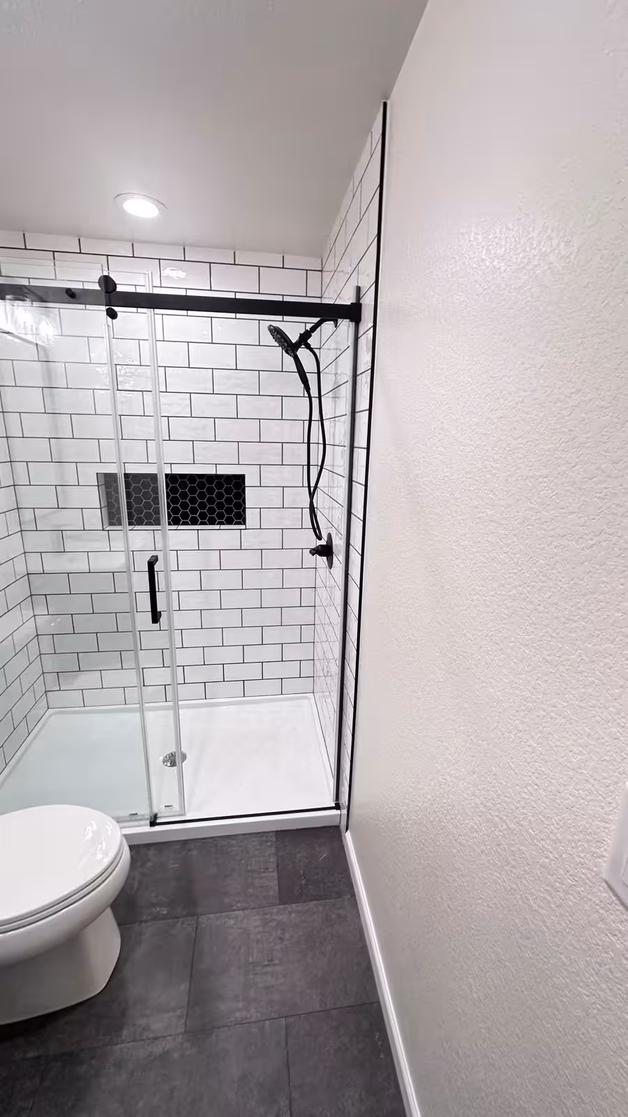 Compact bathroom remodel with white subway tile and black fixtures